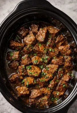 Crock Pot Garlic Butter Steak Bites served on a plate with fresh herbs