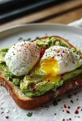 Delicious avocado toast topped with a perfectly poached egg on a wooden table