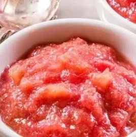 Bowl of classic homemade rhubarb sauce with fresh rhubarb stalks
