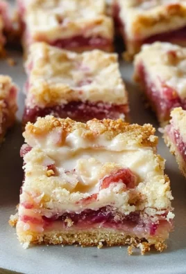 Delicious rhubarb custard bars on a plate, showcasing their creamy texture and vibrant color.
