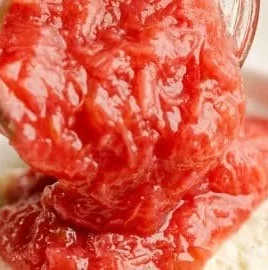 Bowl of easy rhubarb honey sauce drizzled over dessert