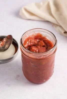 Easy three-ingredient rhubarb sauce in a bowl with fresh rhubarb stalks