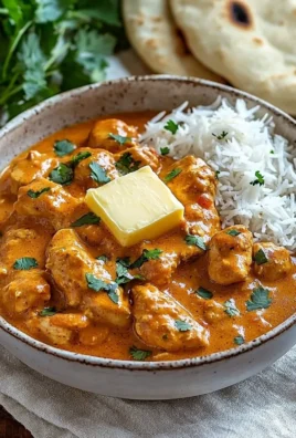 Delicious plate of Indian Butter Chicken garnished with herbs and served with rice.
