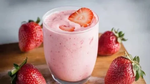Colorful protein smoothies in glasses with fruit and ingredients on a table