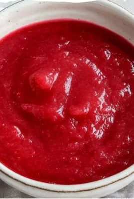 Delicious homemade rhubarb sauce in a jar with fresh rhubarb stalks