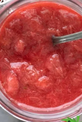 Homemade strawberry rhubarb sauce in a glass jar with fresh strawberries and rhubarb.
