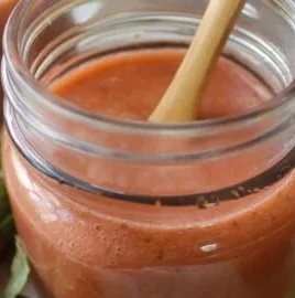 Delicious homemade strawberry rhubarb sauce in a jar ready for freezing.