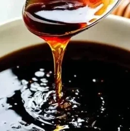 Homemade teriyaki sauce in a glass jar with fresh ingredients.