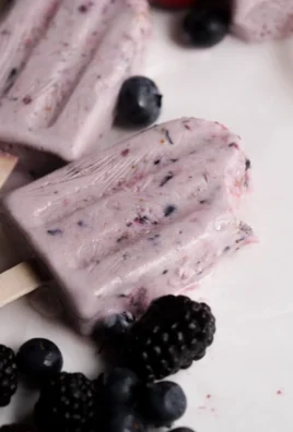 Delicious and healthy berry protein popsicles on a wooden table
