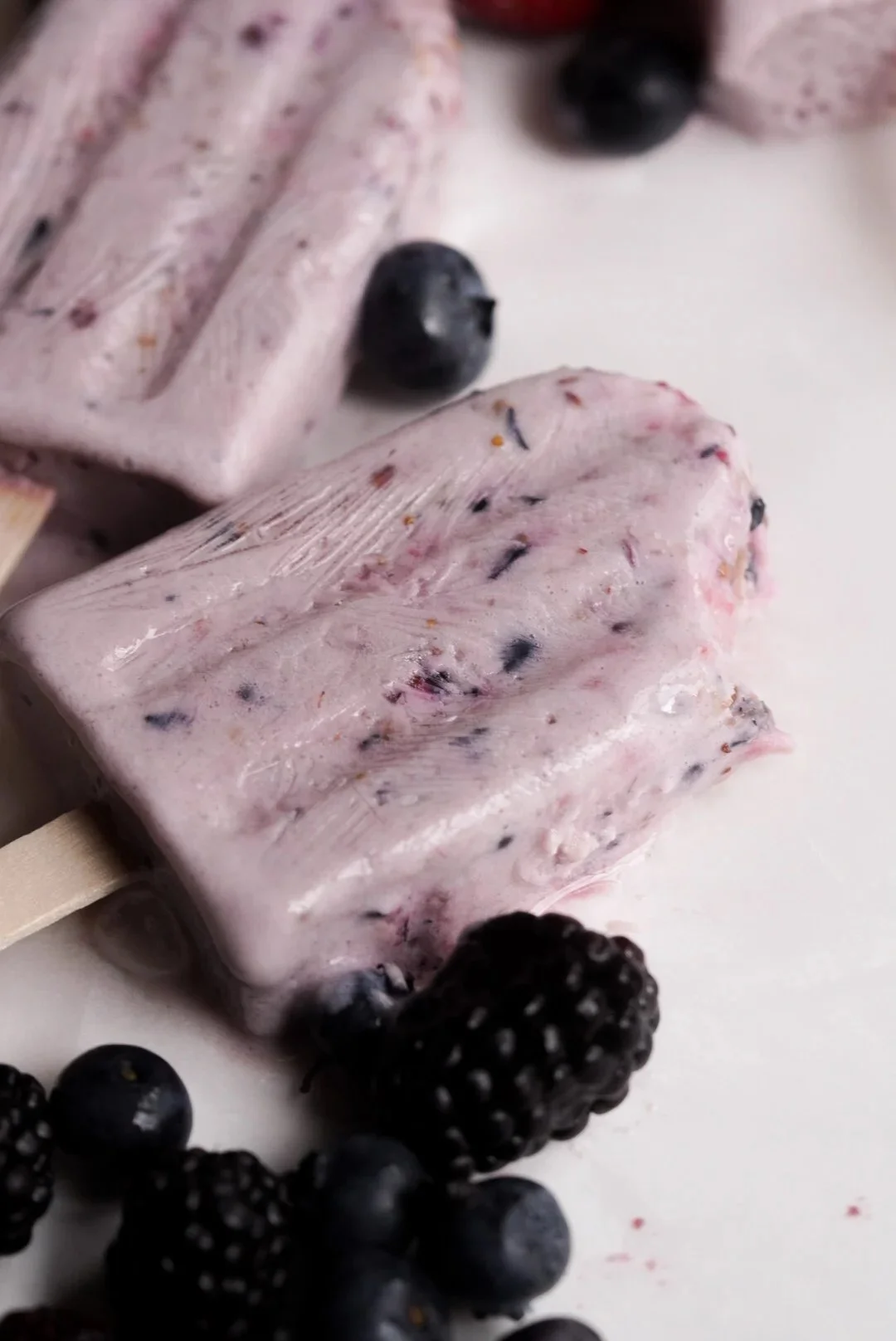 Delicious and healthy berry protein popsicles on a wooden table