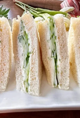 Fresh cucumber cream cheese sandwiches on a platter ready to serve.