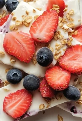 Frozen yogurt bark with berries on a marble countertop.