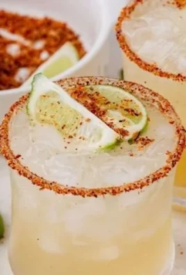 Hot honey margarita cocktail garnished with lime and chili pepper.