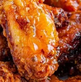 Hot Honey Peach Wings seasoned with spices and garnished with fresh herbs