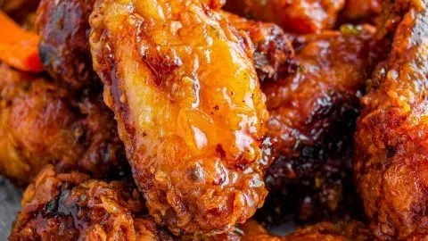 Hot Honey Peach Wings seasoned with spices and garnished with fresh herbs