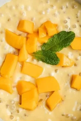 A delicious bowl of Mango Sago dessert topped with fresh mango slices.