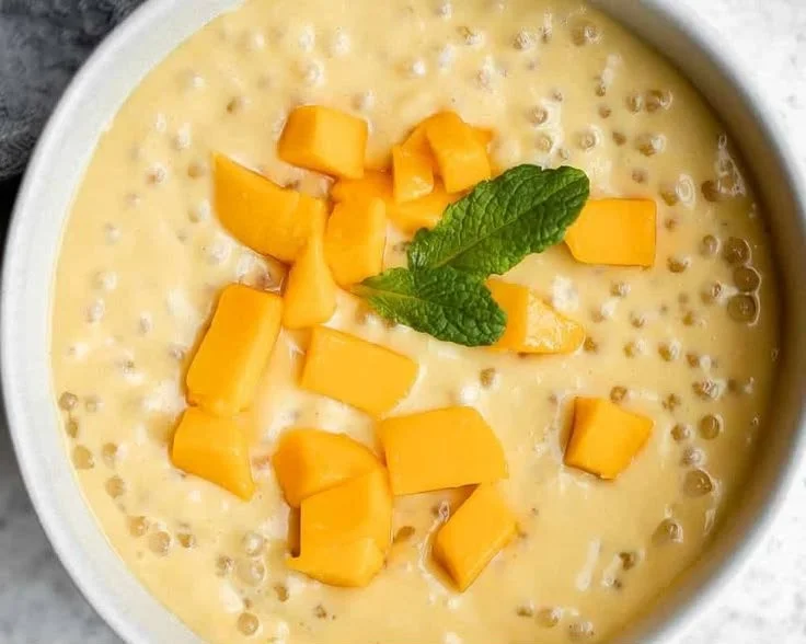 A delicious bowl of Mango Sago dessert topped with fresh mango slices.