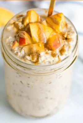 Delicious bowl of Peach Overnight Oats topped with fresh peaches and nuts