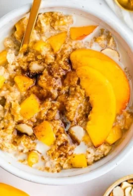 Bowl of Peaches and Cream Oatmeal topped with fresh peach slices and cream