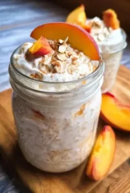 Peaches and Cream Overnight Oats in a bowl, topped with fresh peaches and creamy yogurt.