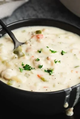 Delicious bowl of clam chowder served with fresh herbs and oyster crackers