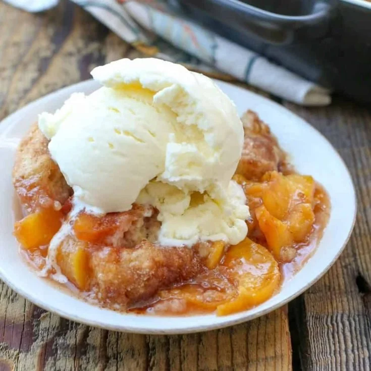 Homemade peach cobbler made with fresh and canned peaches topped with golden crust