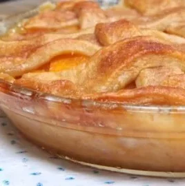 Delicious easy peach cobbler served in a baking dish with fresh peaches