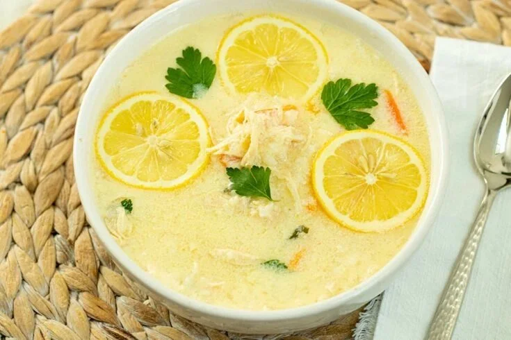 Delicious Greek chicken Avgolemono soup served in a bowl with lemon and herbs