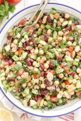 Colorful Mediterranean bean salad with fresh vegetables and herbs