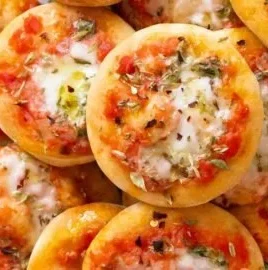 Colorful mini pizzas with various toppings on a baking sheet