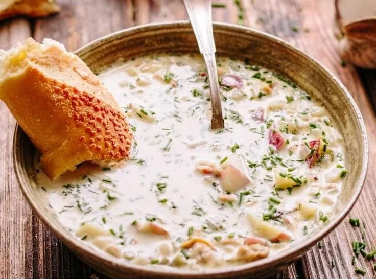 Bowl of creamy New England clam chowder topped with parsley