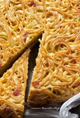 Delicious spaghetti frittata garnished with herbs on a rustic plate