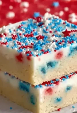 Patriotic sugar cookie bars decorated with red, white, and blue sprinkles