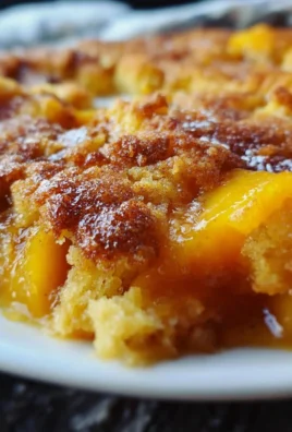Delicious peach cobbler made with cake mix, served warm with ice cream.