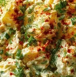 A bowl of Southern potato salad with eggs, celery, and seasoning