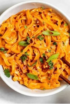 Delicious Thai red curry noodles garnished with fresh herbs and vegetables
