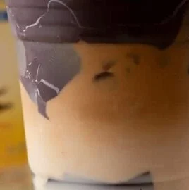 A deliciously brewed cracking latte topped with frothy milk and chocolate drizzle.