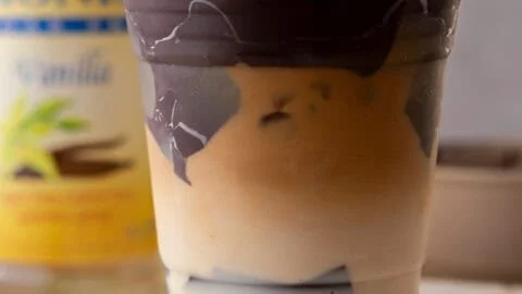 A deliciously brewed cracking latte topped with frothy milk and chocolate drizzle.