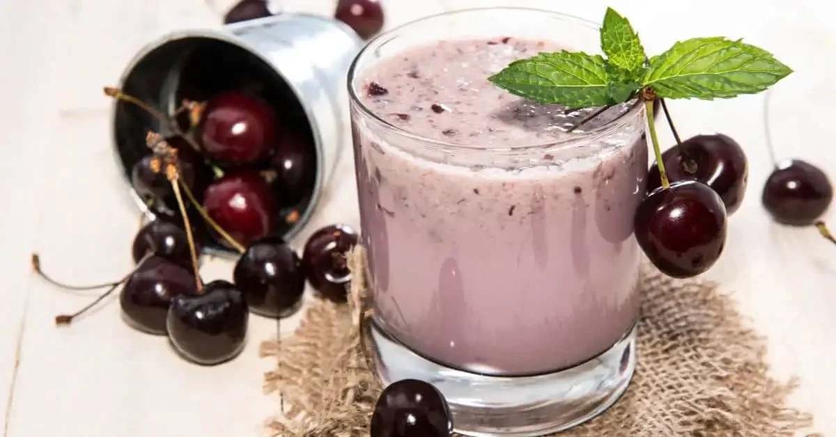 A delicious Cherry Vanilla Smoothie topped with cherries and whipped cream.