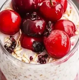 Bowl of delicious cherry overnight oats topped with fresh cherries and nuts