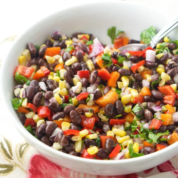 Bowl of colorful Mexican Bean Salad with beans, vegetables, and lime dressing.