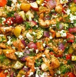 Greek sheet pan chicken served with colorful roasted veggies
