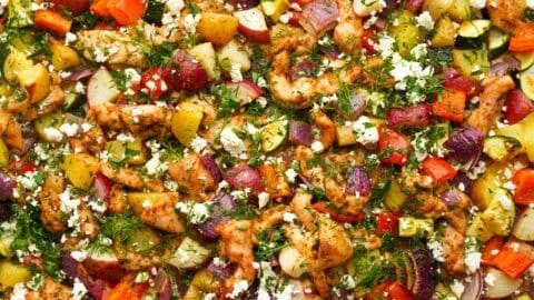 Greek sheet pan chicken served with colorful roasted veggies