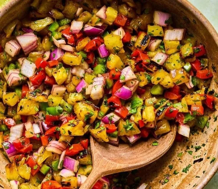 Delicious Grilled Pineapple Salsa served in a bowl with fresh herbs.