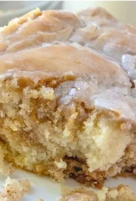 Delicious homemade cinnamon roll cake topped with creamy glaze and cinnamon swirls.
