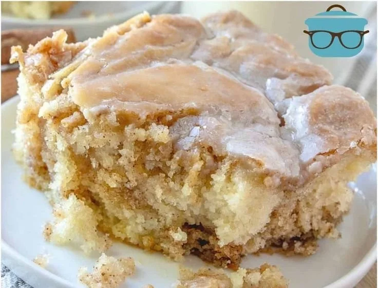 Delicious homemade cinnamon roll cake topped with creamy glaze and cinnamon swirls.