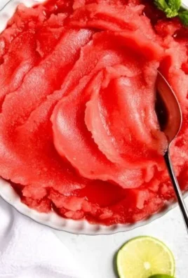 A bowl of homemade watermelon sorbet garnished with mint leaves