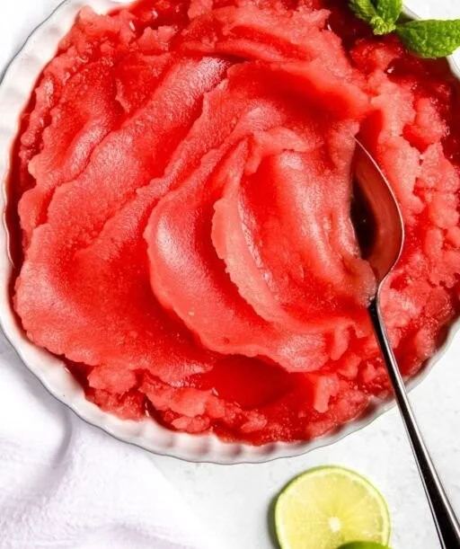 A bowl of homemade watermelon sorbet garnished with mint leaves
