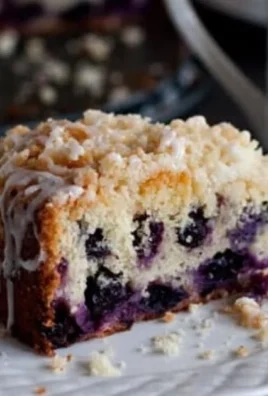 A delicious slice of Lemon Blueberry Coffee Cake on a plate, garnished with blueberries.