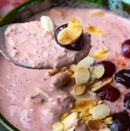 Delicious Overnight Cherry Oats in a glass jar with fresh cherries on top